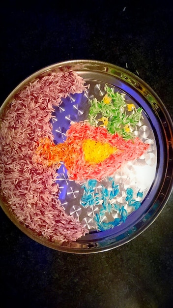 A close-up of a Petri dish containing microorganisms that are producing a vibrant, colorful material, showcasing the potential of synthetic biology in material creation.