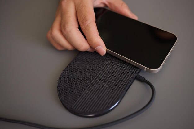 A close-up of a smartphone being wirelessly charged on a sleek charging pad, showcasing the magnetic coils and energy transfer process.