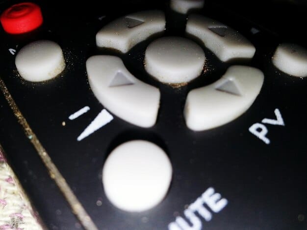 A close-up of a Smart TV remote control with a highlighted button representing the settings menu. The reflection on the screen showcases various streaming apps, underlining the data collection from these platforms.
