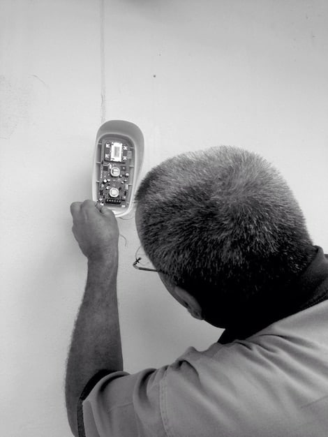 A close-up shot of an electrician installing a Level 2 EV charger on a garage wall with tools and wiring visible, showcasing the technical aspects of the installation process.