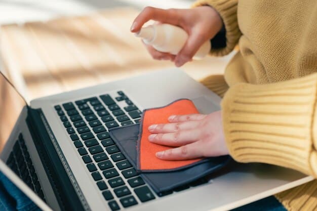A person carefully cleaning the screen of a laptop with a microfiber cloth, emphasizing the importance of regular maintenance to prolong the life of electronic devices.